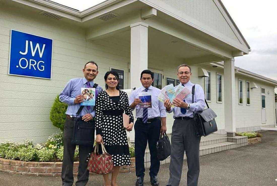Jehovah’s Witnesses members pose for a photograph in front of a house of worship in Japan